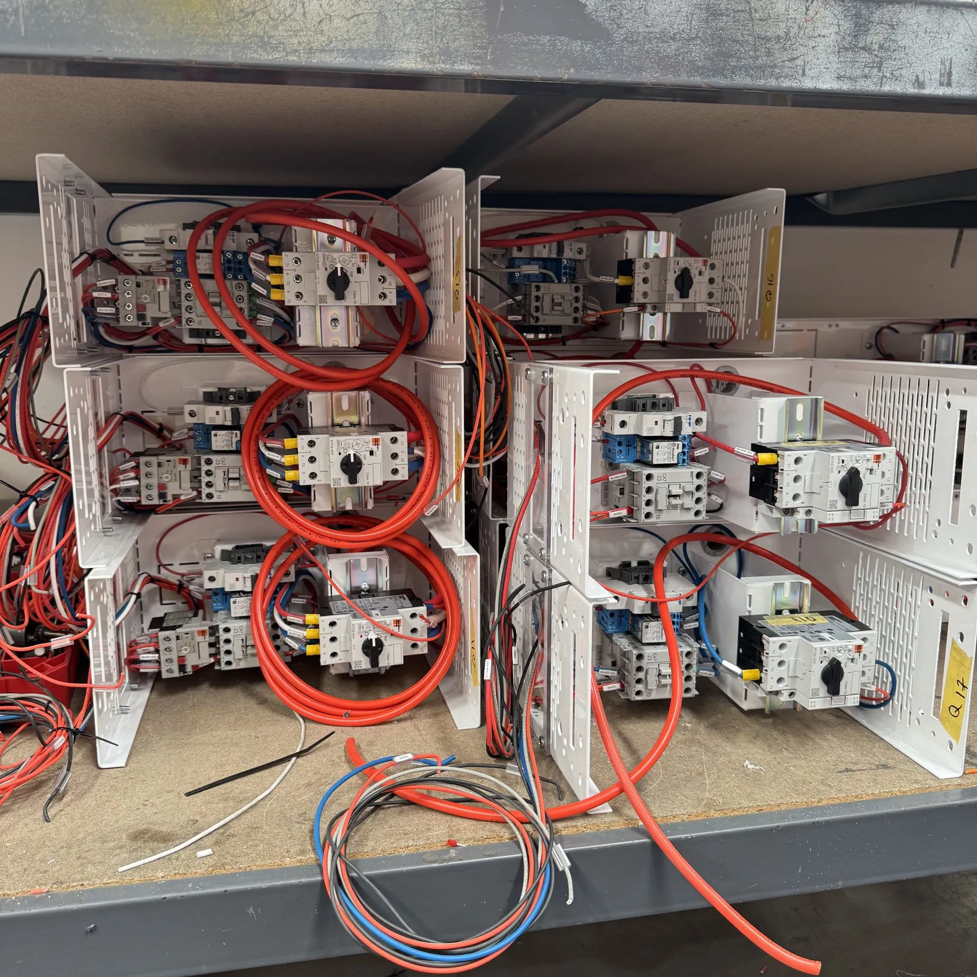 Pre-wired starter assemblies with contactors and motor protection breakers laid out on a workshop bench