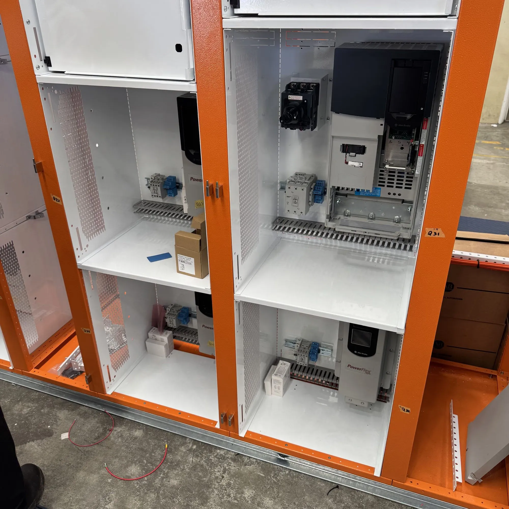New switchboard cubicles being fitted out with variable speed drives and isolators on white gear plates